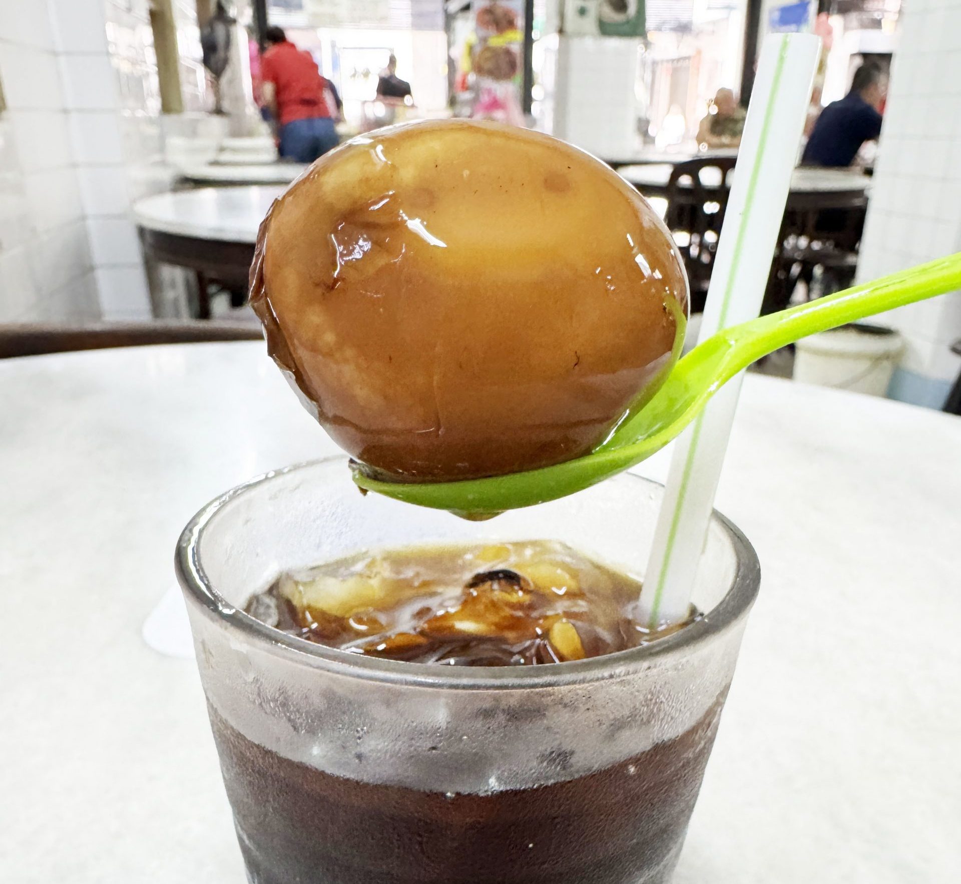 玉子入りアイスティーの卵を食べながらアイスティーを飲む / 名物料理として大人気